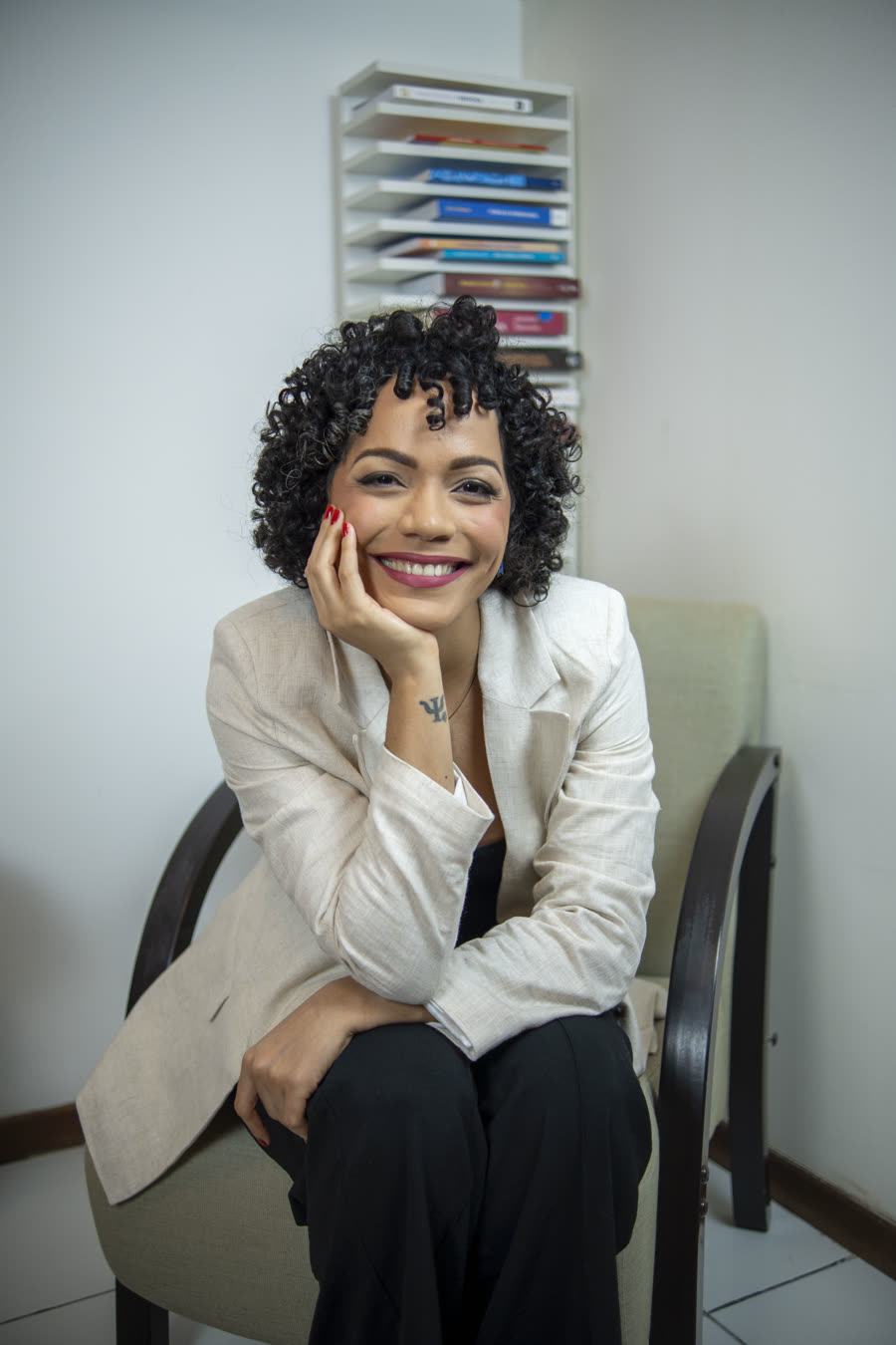 Lana Ohana, psicóloga, sorrindo em seu consultório
